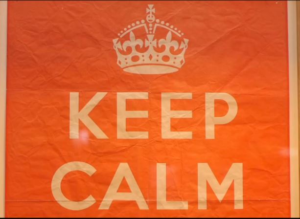 A close up of an orange keep calm sign