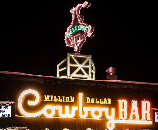 A neon sign that reads " million dollar cowboy bar ".