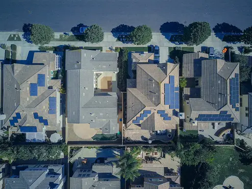 A bird 's eye view of houses with blue roof tiles.