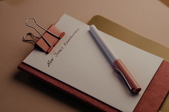 A pen and paper on top of a clipboard.