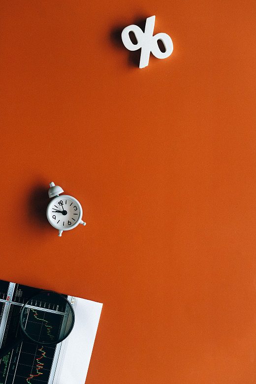 A clock on the wall of an orange room.