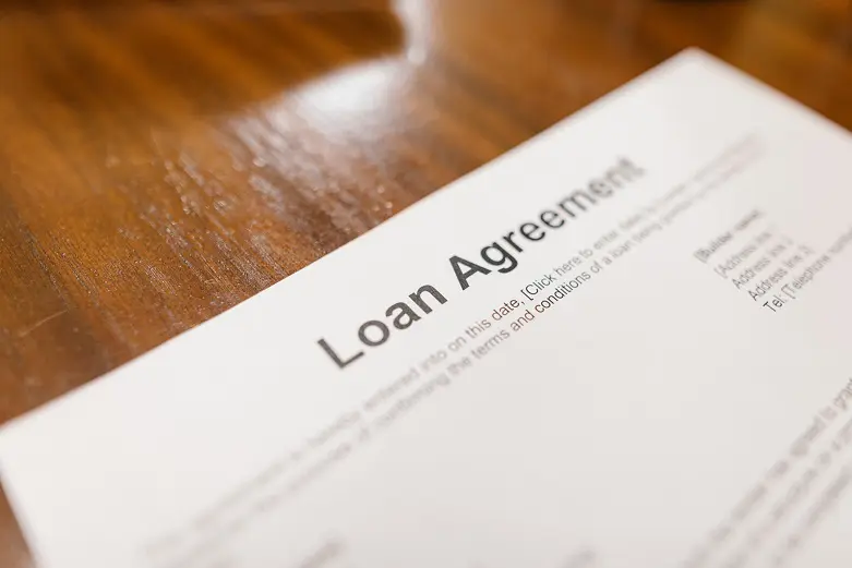 A loan agreement is written on top of the table.